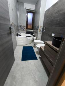 a bathroom with a sink and a toilet and a tub at DyAndy Suites Expo Milano in Baranzate