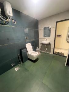 a bathroom with a toilet and a sink at Hotel Sun Icon in Vadodara +7 photos