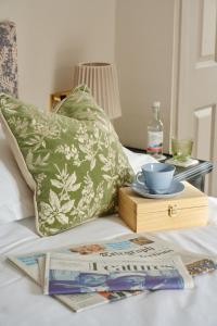 a bed with a tray of books and a plate on it at Bankes Arms Hotel in Wareham