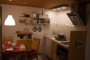 a kitchen with a table and a sink and a stove at Ferienwohnung Küssner in Kiel