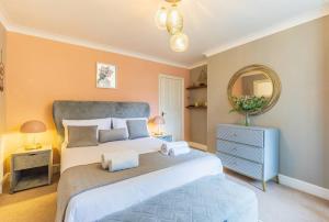 a bedroom with a large bed and a mirror at Spacious Seafront Apartment, Garden Free Parking in Littlehampton