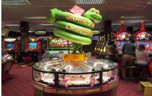 a pinball machine in a casino with people playing at Spacious Seafront Apartment, Garden Free Parking in Littlehampton