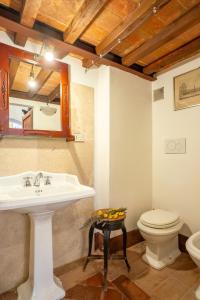 a bathroom with a sink and a toilet and a mirror at Palazzo Danesi in Montepulciano