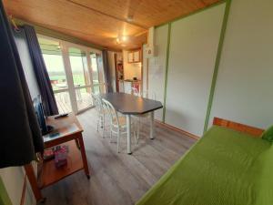 a room with a table and chairs and a kitchen at Les Chalets du Quignon in Autry-le-Châtel +36 photos