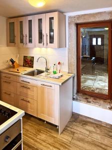 a kitchen with a sink and a large window at Ferienwohnungen Elbjuwel in Rathen +28 photos
