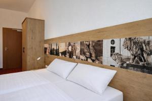 a bedroom with a white bed with a wooden headboard at Gasthof Klement in Isen +34 photos