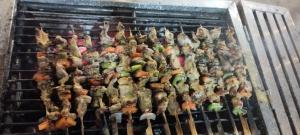 a bunch of food cooking on a grill at Teko Paradise and Kitchen in Phumĭ Kruŏs