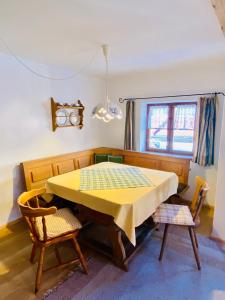 a dining room with a yellow table and two chairs at City Apartment in Oberammergau