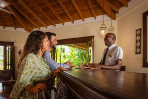a woman and two men standing at a bar at Ocean Beach Resort & SPA in Malindi +92 photos