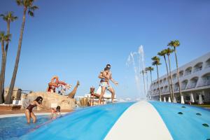 a group of people playing in the water at a swimming pool at Iberostar Waves Royal Andalus in Chiclana de la Frontera +88 photos