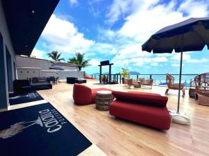 a patio with a red couch and an umbrella at Casatua Pousada in Juquei