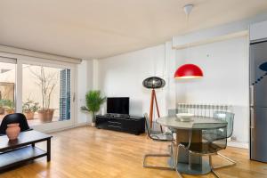 a living room with a glass table and a tv at Flateli Nord in Girona