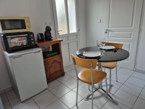 a small kitchen with a table and a microwave at Chambre Is in Is-sur-Tille +12 photos