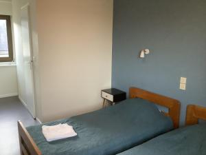 a bedroom with a bed with a green bedspread and a window at Le village Gr34 louannec in Louannec