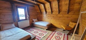 a room with two beds in a wooden cabin at Snow Dreams Bungalow Hotel in Türkmenoğlu