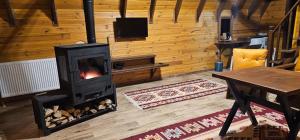 a living room with a fireplace in a log cabin at Snow Dreams Bungalow Hotel in Türkmenoğlu