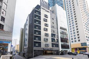a tall building in a city with tall buildings at Lien Hotel Haeundae in Busan