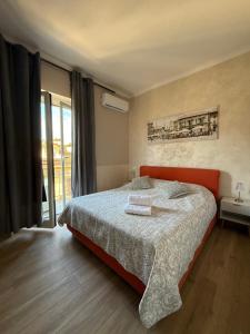 a bedroom with a bed with an orange headboard at Panoramic Apartment 5Terre La Spezia in La Spezia