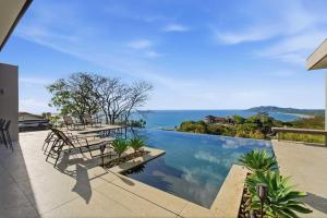 a swimming pool with a view of the ocean at Infinity Pool Villa , 4 Suites & Private Casita in Tamarindo +28 photos