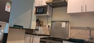 a kitchen with a stove and a microwave at 3C Palm Ridge Vipingo in Kilifi