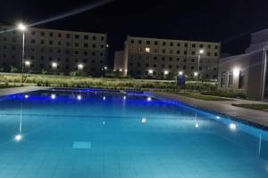 a swimming pool at night with buildings in the background at 3C Palm Ridge Vipingo in Kilifi