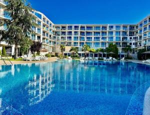 a large swimming pool in front of a large building at Sunset Apartment Atlantis Resort in Burgas