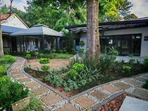 a garden with a stone walkway in front of a house at Cascades Guest Lodge in Nelspruit