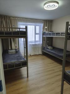 a room with three bunk beds and a window at Tara Guesthouse and Tours in Ulaanbaatar