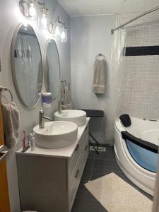 a bathroom with two sinks and a tub and mirror at Catskill Mountain Retreat in West Kill +79 photos
