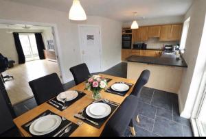a dining room with a table and chairs and a kitchen at Large 3 bed Duplex Apartment - Rhebogue Limerick in Limerick