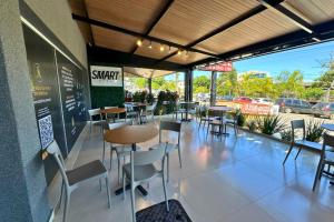 a restaurant with tables and chairs and a parking lot at Smart Hotel Aeroporto by Bsb Inn in Brasília