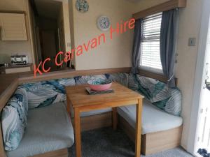 a room with a table and a caravan life sign on the wall at KC Caravan Hire in Kinmel Bay +15 photos