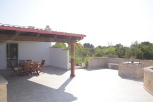 a patio with a table and chairs on it at Villa Alessandro in Poggiardo