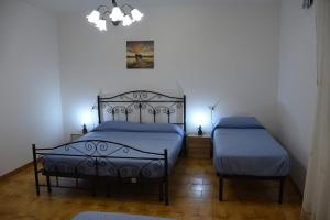 a bedroom with a bed and a chair in it at Villa Alessandro in Poggiardo