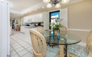 a kitchen and dining room with a glass table and chairs at Phoenix East 1401 in Orange Beach
