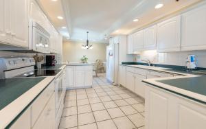 a large kitchen with white cabinets and black counter tops at Phoenix East 1401 in Orange Beach