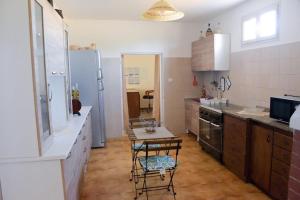 a kitchen with a table and a refrigerator at Villa Alessandro in Poggiardo