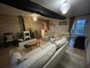 a living room with white couches and a fireplace at The Old Farm Gite in Amfreville