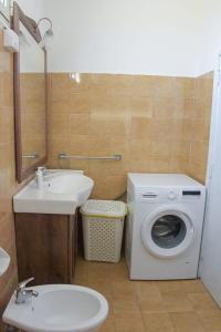 a bathroom with a washing machine and a sink at Villa Alessandro in Poggiardo