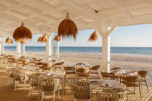 a restaurant on the beach with tables and chairs at Iberostar Waves Royal Andalus in Chiclana de la Frontera