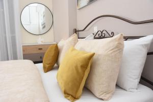 a bedroom with a bed with yellow pillows and a mirror at Sparta Central Apartment with Free Parking in Sparta