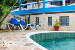 a resort with two chairs and a swimming pool at Hotel El Tronco Inc in Boca Chica
