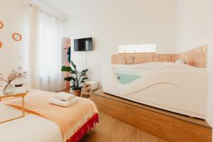 a bathroom with a tub and a bed in a room at Le Spa by SCH in Le Havre