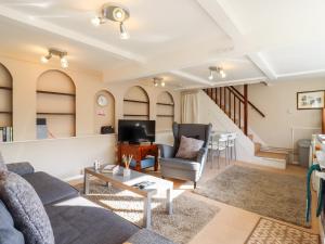 a living room with a couch and chairs and a table at Vine Cottage in Halstead