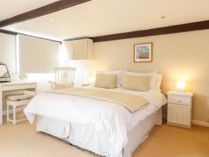 a bedroom with a large white bed and a window at Vine Cottage in Halstead