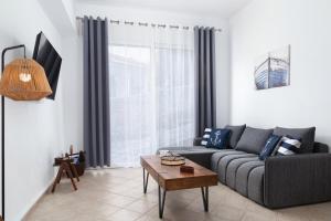 a living room with a couch and a table at Andros Apartments with Free Parking in Steniaí