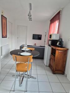 a living room with a table and a kitchen at Chambre Is in Is-sur-Tille