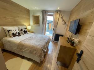a bedroom with a large bed and a television at Chalet Millou Beuil in Beuil