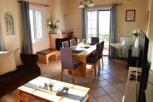a living room with a table and chairs and a couch at Aegina3views in Kipséli