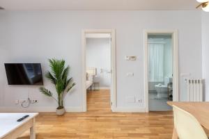 a white living room with a potted plant and a television at Flateli Nord in Girona +118 photos